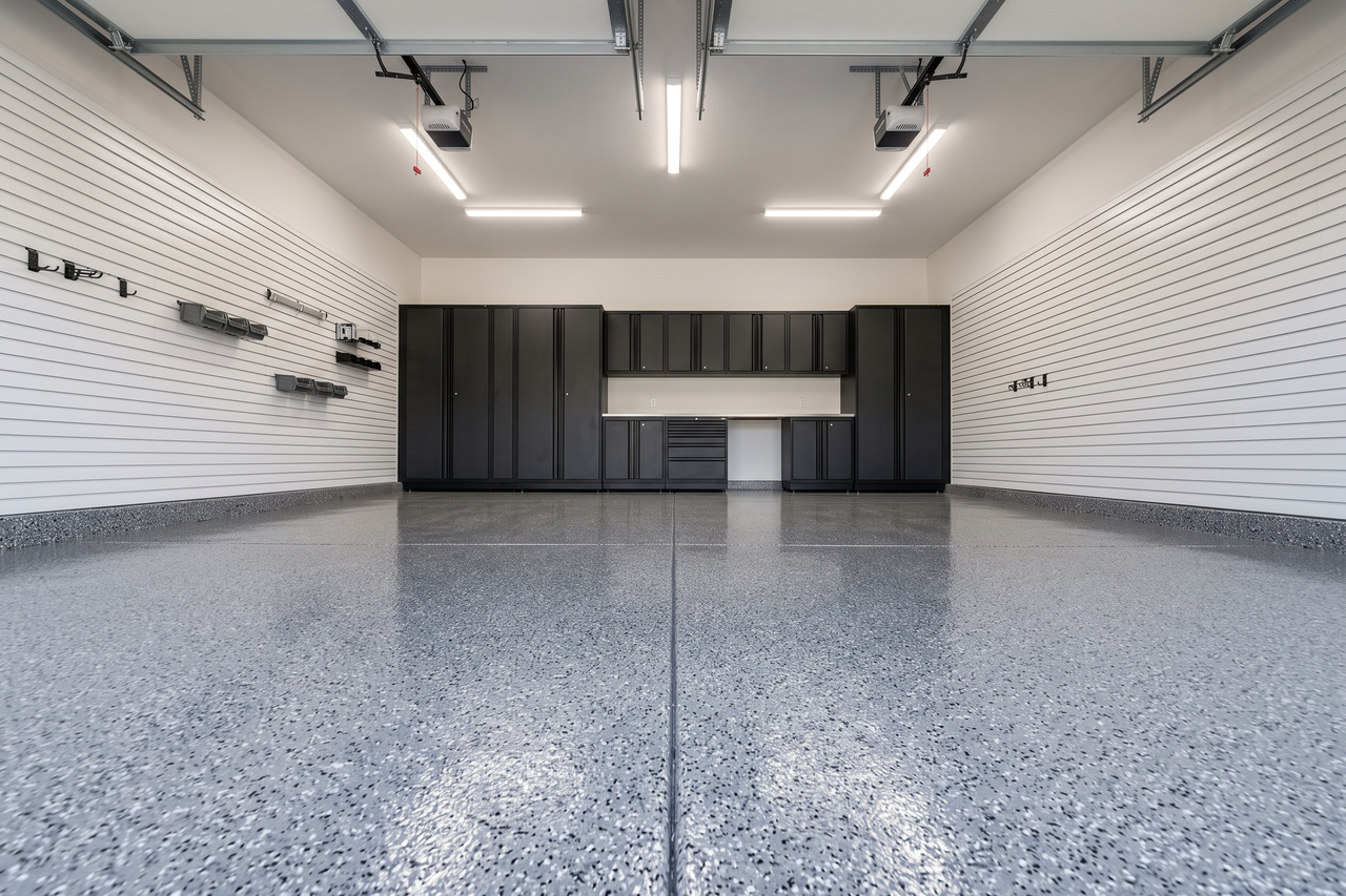 Gray flake epoxy floor coating on a two-car garage slab with a clean, bright finish